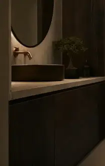 Lo specchio ovale, il rubinetto in rame e il lavabo in pietra